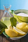 Fresh lemons with leaves, lemon juice and sugar