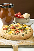 Pizza with cherry tomatoes, capers and rosemary