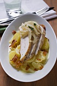 Potato salad with bacon, chicken breast and onions
