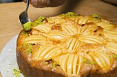 Sprinkling apple cake with chopped pistachios
