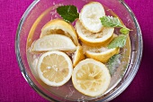 Ausgepresste Zitronen im Wasser in Glasschale