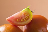 Wedge of tomato on whole tomatoes