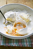 Mehl, aufgeschlagenes Ei und Butter in Schüssel