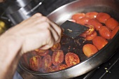 Turning tomatoes in frying pan