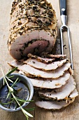 Rolled pork roast with herbs, partly carved