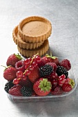 Mixed berries in plastic punnet and tart cases