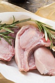 Raw pork chops and rosemary in paper