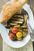 Grilled aubergines with cherry tomatoes, capers, flatbread