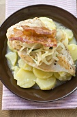 Chicken breast with bacon and onions on potato salad