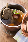 Broth with beef and soup vegetables in pot