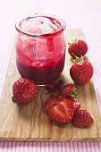 Jar of strawberry jam & fresh strawberries on chopping board