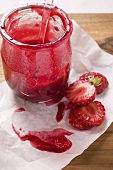 Strawberry jam and fresh strawberries on paper