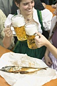 Two women clinking litres of beer at Oktoberfest