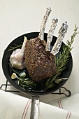 Rack of venison with garlic and rosemary in frying pan