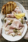 Cold roast pork with capers, lemon and toasted bread