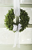 Christmassy door wreath of box with white bow
