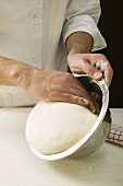Taking pizza dough out of bowl