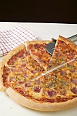 American-style ham pizza, cut into pieces