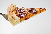 Stück Pizza mit Peperoniwurst (amerikanische Art) auf Heber