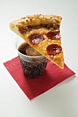 Slice of American-style pepperoni pizza on cola