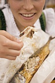 Woman eating Steckerlfisch (fish on stick, Oktoberfest, Munich)