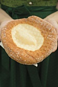 Woman holding Auszogene (Bavarian fried pastry) on napkin