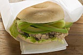 Bagel filled with avocado, tuna salad and capers