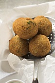 Falafel (chick-pea balls) on slotted spoon