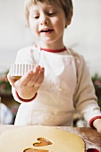 Small boy cutting out biscuits