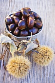 Chestnuts in bowl on wooden table