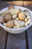 Walnuts and peanuts in white bowl