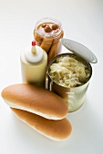 Bread rolls, sauerkraut in tin, mustard, frankfurters in jar