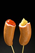 Two half frankfurters with mustard and ketchup