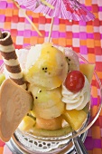 Ice cream sundae with fresh fruit and cocktail umbrella