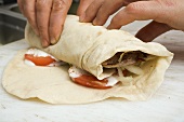 Making a döner wrap (rolling up)