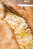 Pide (Turkish flatbread) with sheep's cheese filling, close-up