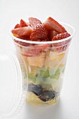 Fruit salad with strawberries in a plastic beaker