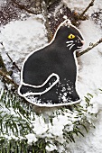 Black gingerbread cat with fir branches