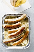 Sausages with sauerkraut in aluminium container to take away