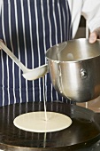 Pouring pancake mixture onto hotplate