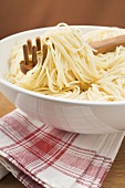 Spaghetti with spaghetti server in large bowl