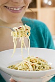 Young woman eating spaghetti with chillies