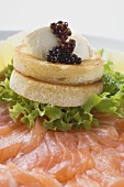 Soft cheese and caviar on toast on smoked salmon