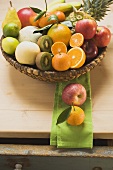 An assortment of fresh fruit in a basket on a wooden table
