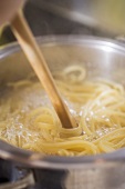 Stirring ribbon pasta during cooking