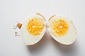 Hard-boiled egg with shell, halved