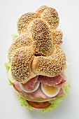 Sesame plait filled with salami, egg, ham and cheese