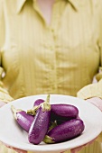 Woman holding plate of aubergines