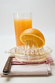 Squeezing an orange, glass of orange juice