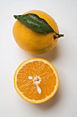 Ganze Orange mit Blatt und Orangenhälfte